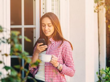 Junge Frau stellt HomeKit am iPhone ein.