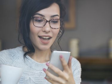 Frau schaut auf ihr Samsung-Handy.