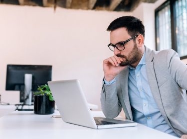 Man grübelt vor seinem Laptop