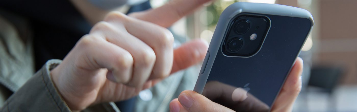 Frau wischt mit Finger auf iPhone 12