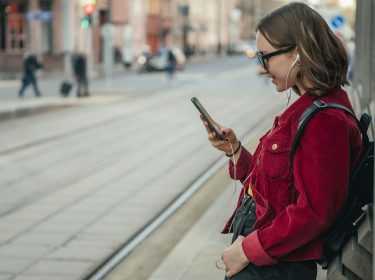 Frau öffnet Google Maps am Handy.