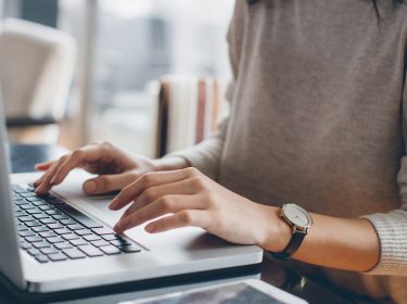 Frau schreibt E-Mail am Laptop