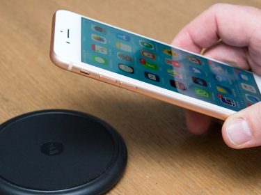 Hand legt iPhone 8 Plus auf Ladestation