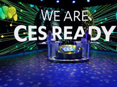 iJustine und Rich DeMuro bei der digitalen CES 2021. Auf einem Bildschirm hinter ihnen ist 