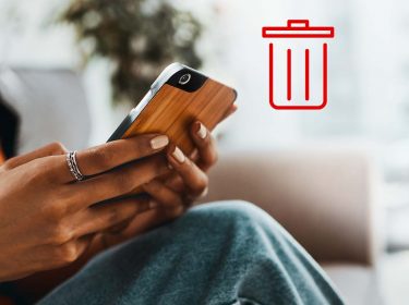 Frau bedient Smartphone, Symbolbild mit Papierkorb-Emoji