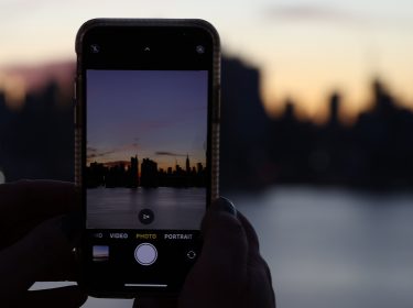 Smartphone fotografiert Skyline von New York im Sonnenuntergang