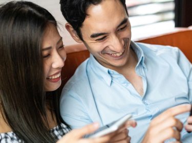 Paar schaut sich ein iPhone an.