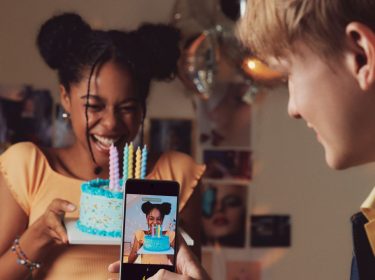Junge macht Foto mit einem Mittelklasse-Smartphone.