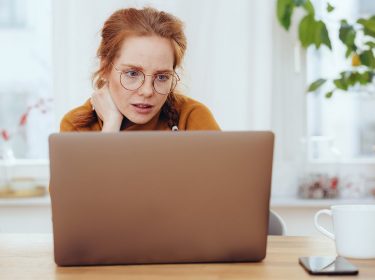 Frau schaut etwas ratlos auf ihren Laptop