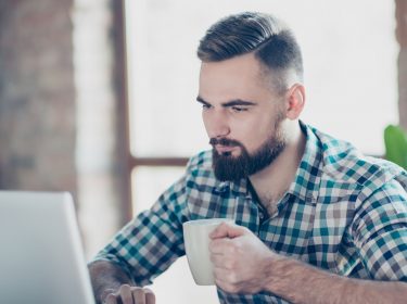 Mann arbeitet am Laptop