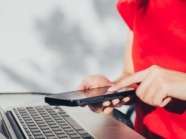 Frau tippt auf ihr iPhone.