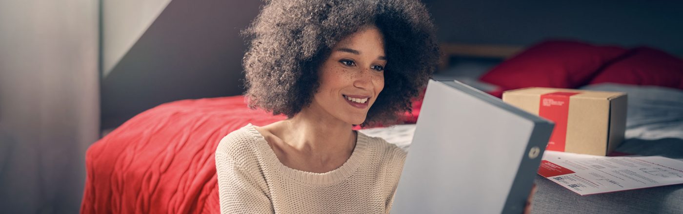 frau öffnet ihr paket von vodafone und nimmt den Kabel-router raus