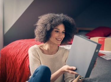 frau öffnet ihr paket von vodafone und nimmt den Kabel-router raus