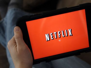 Mann schaut Netflix auf seinem Tablet.