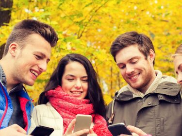 Freunde zocken am Smartphone.