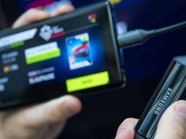 Hand hält Samsung Galaxy Note 9 und Kabel vor Bildschirm