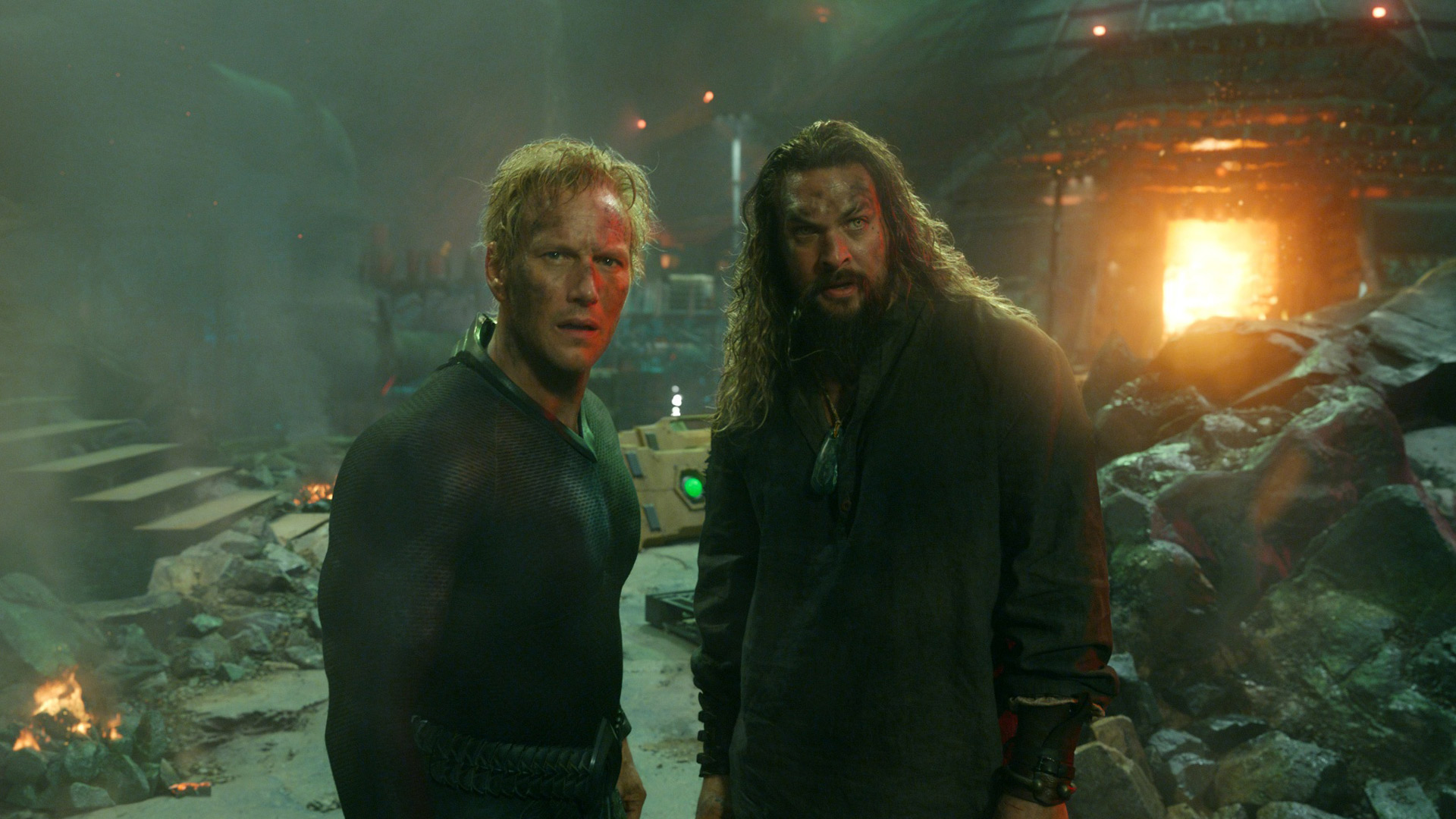 In dieser Szene aus Aquaman and the Lost Kingdom stehen Jason Momoa als Aquaman und Patrick Wilson als Orm Seite an Seite in einer zerstörten Unterwasseranlage. Beide blicken ernst und entschlossen in Richtung Kamera, im Hintergrund lodert Feuer zwischen Trümmern. Ein intensiver Moment aus Jason Momoa beste Filme und Serien.