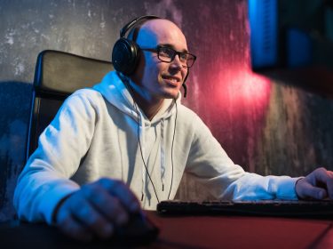 Mann mit Gaming-Headset sitzt am Computer