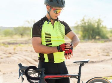 Fahrradfahrer schaut auf seine Smartwatch.