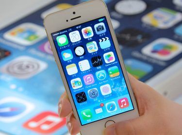 Hand hält iPhone 5s mit Daumen auf Fingerabdrucksensor