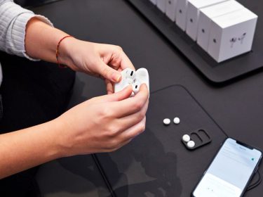 Frau hält AirPods Pro im Ladecase in der Hand