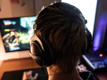 Mann mit Kopfhörern beim Gaming am Computer