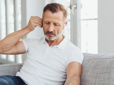 Mann prüft die Einstellungen seiner AirPods Pro, weil sie rauschen