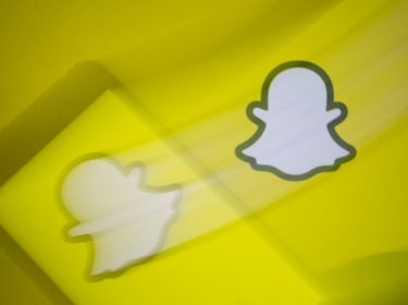 Snapchat-Logo vor einem Smartphone-Display