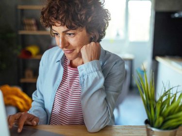 Eine Frau sitzt an ihrem Laptop