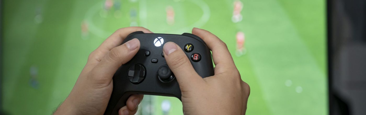 Ein Mann hält den Xbox-Controller in der Hand.