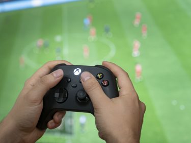 Ein Mann hält den Xbox-Controller in der Hand.