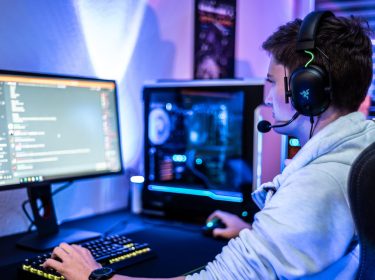 Ein Mann sitzt am Computer und chattet über Discord.