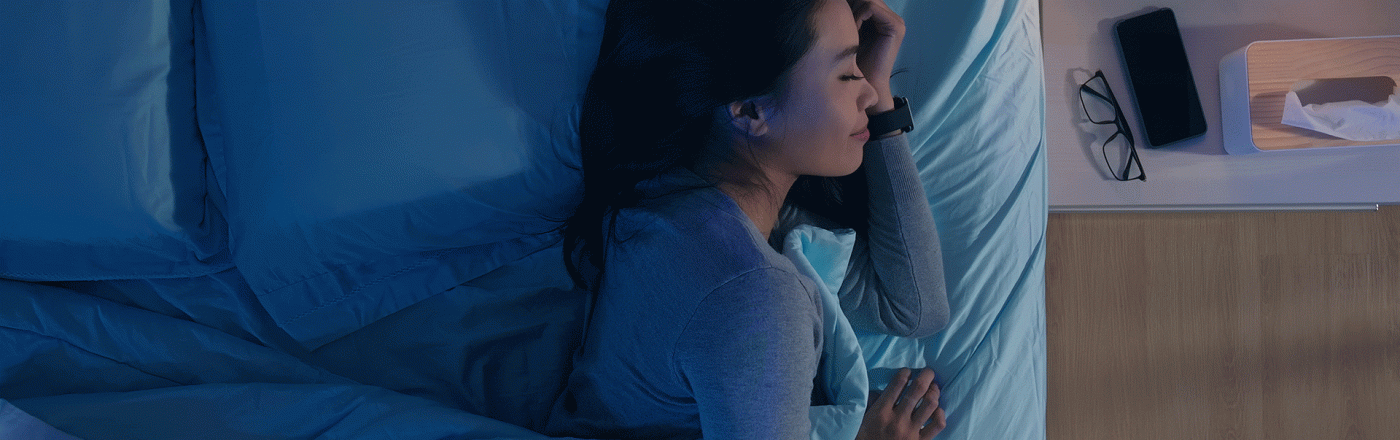 Frau schläft neben Handy, das DreamLab benutzt