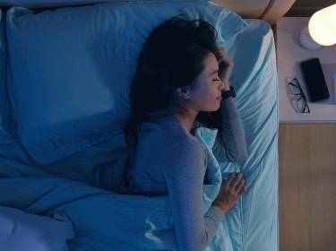 Frau schläft neben Handy, das DreamLab benutzt