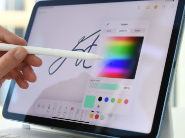 Frauenhand führt Stift auf einem iPad und wählt aus Farbpalette aus