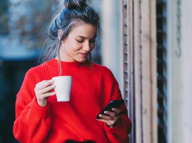 Frau schaut auf ihr iPhone.