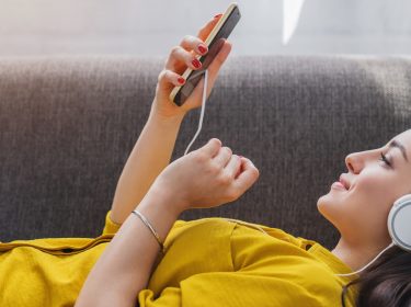 Junge Frau mit Kopfhörer und Handy