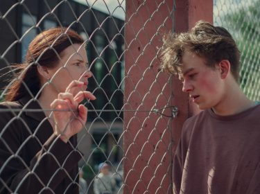 Eine Frau, ein Zaun, ein junger Mann