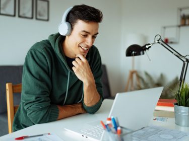 Ein junger Mann lernt online mit einem KI-Tutor