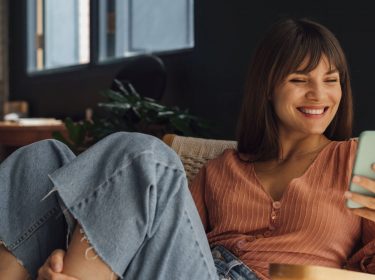 Frau schaut auf ihren Twitter-Thread am Handy.