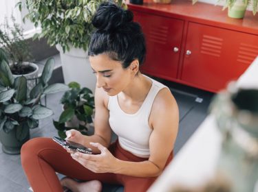 Frau hält ein Smartphone in der Hand.