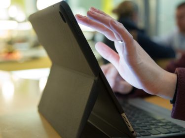 Frauenhände tippen auf iPad mit Tastatur