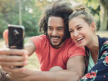 Zwei Personen schauen auf ein Smartphone