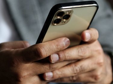 Mann hält iPhone 13 Pro Max in der Hand.