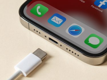 iPhone auf hellem Untergrund mit USB-C-Kabel