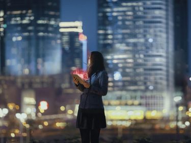 Eine Frau steht vor der Skyline einer Stadt
