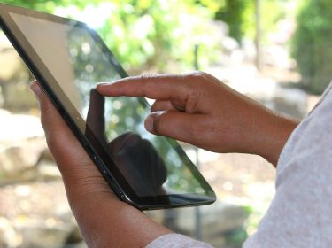Frau hält ein Tablet in der Hand