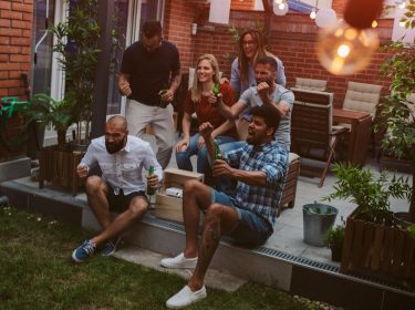 Eine Gruppe schaut gemeinsam Fußball im Garten