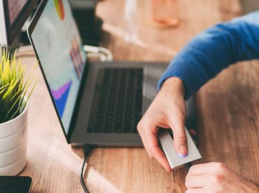 Mann lädt MacBook auf