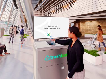 Eine Frau wirft eine Flasche in den smarten Mülleimer Trashbot